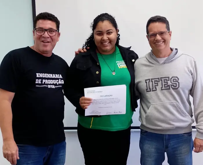 Imagem de uma estudante do Programa Autonomia e Renda Petrobras no IFES recebendo certificado de conclusão do curso de Montador de Andaimes.