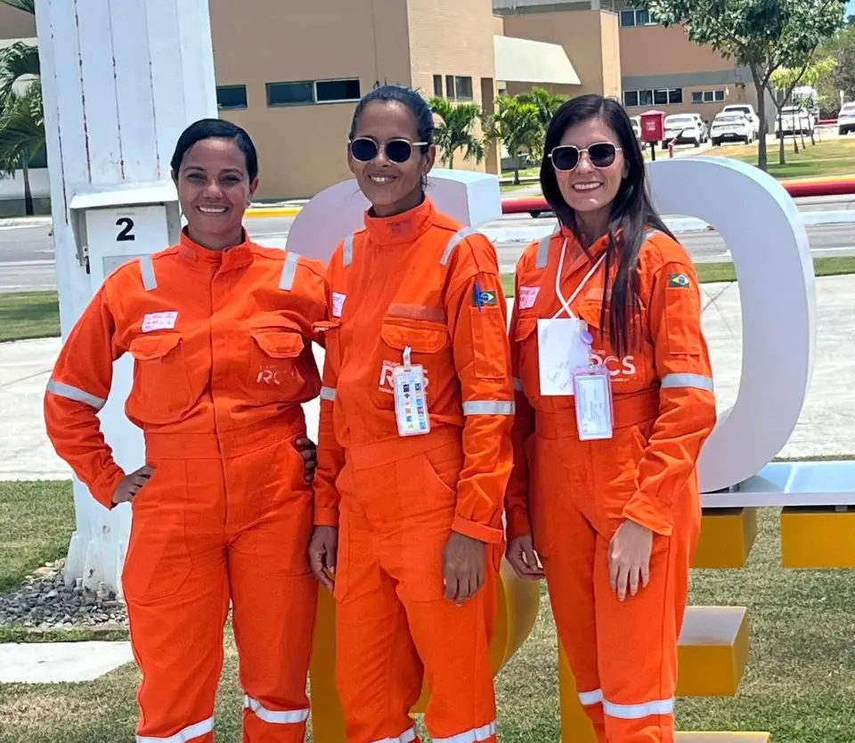 Imagem de 3 egressas do Programa Autonomia e Renda Petrobras do IFPE vestidas com a farda da empresa.