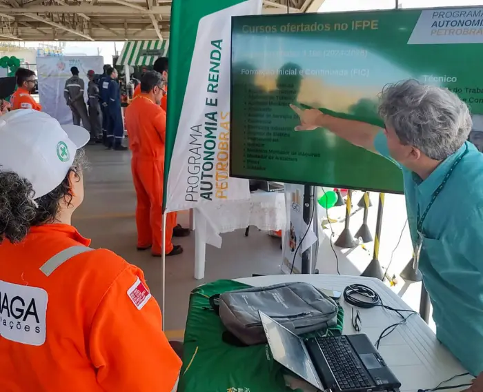 Imagem de um servidor do IFPE num stand no evento SIPAT na Refinaria Abreu e Lima (RNEST).