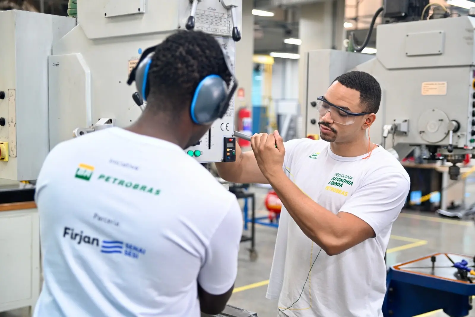 Imagem de estudantes do Programa Autonomia e Renda do SENAI manuseando uma máquina.